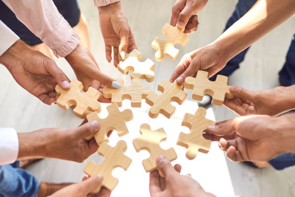 Business man hand holding wooden people figures in outstretched hands