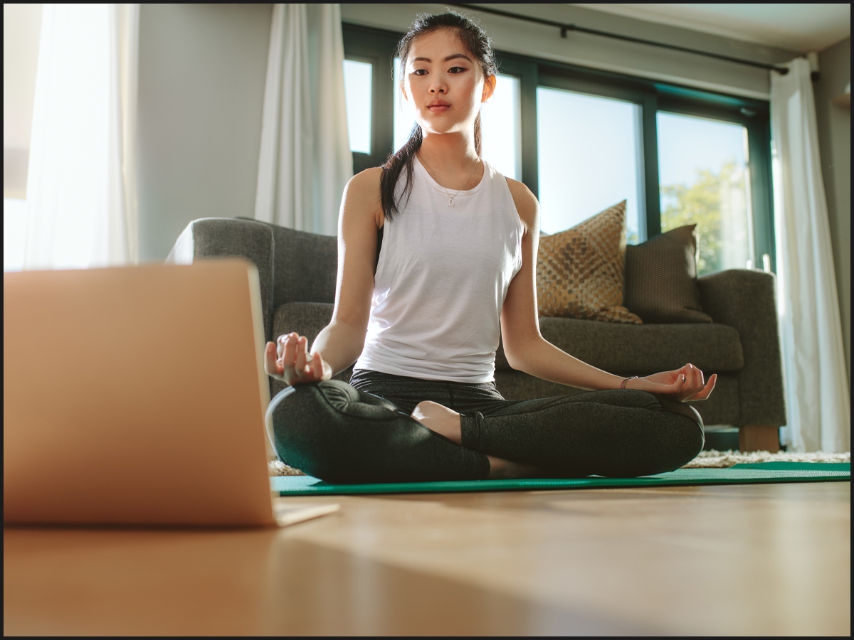Woman using laptop to do yoga