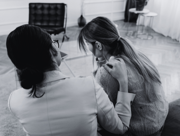 woman touching shoulder empathetically of another woman