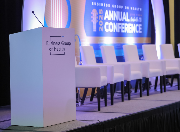 Photo of podium and panel chairs on Business Group on Health conference stage